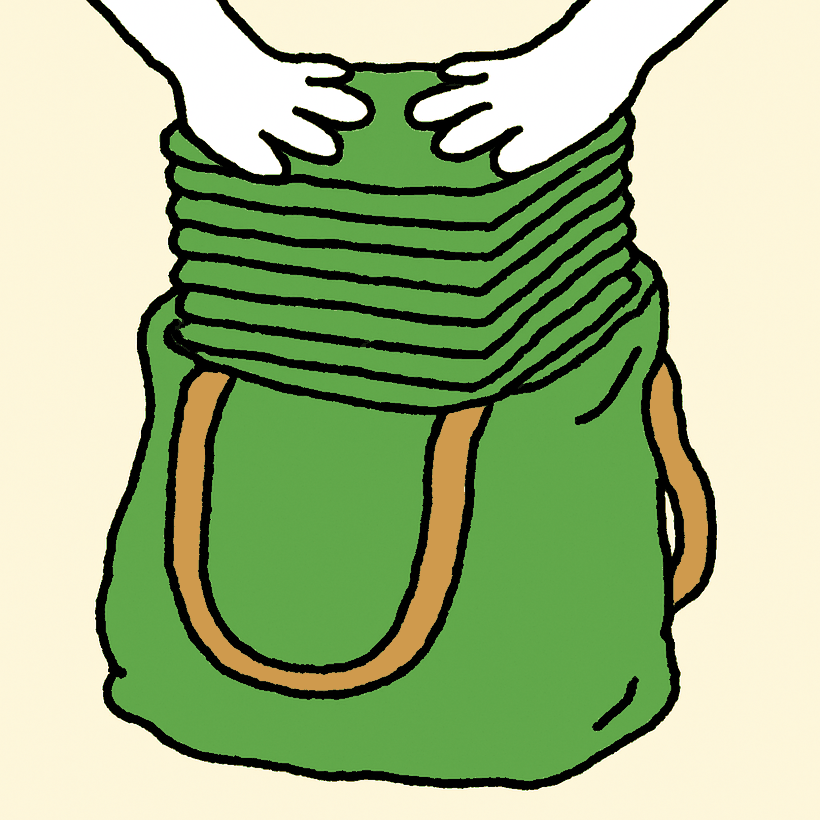 A green cloth tote bag packed past the brim with a thick stack of identical folded totes, two hands pressing down on top to make them fit